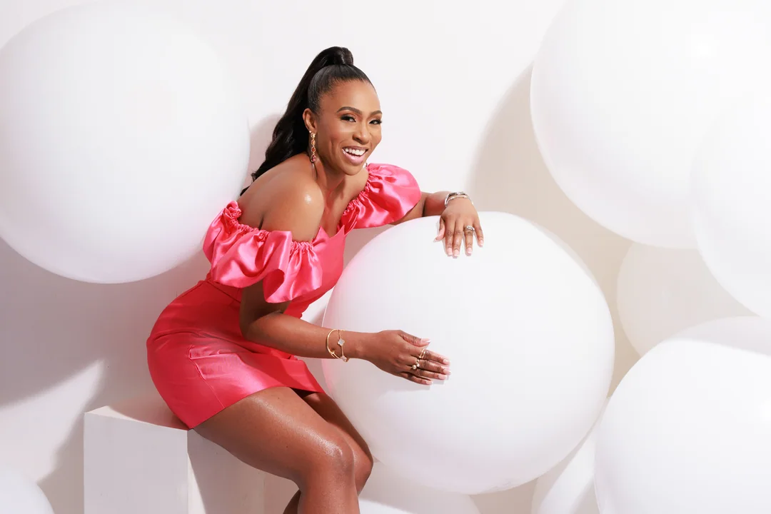 Woman in a coral dress among white balloons