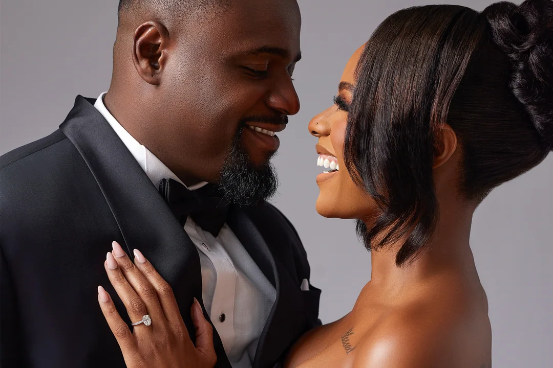 Bride and groom in evening wear facing each other and laughing