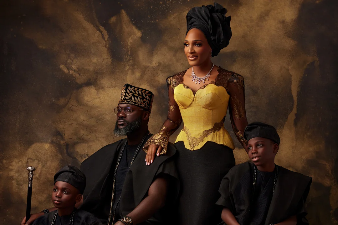 Family in black and gold traditional attire against a bronze backdrop